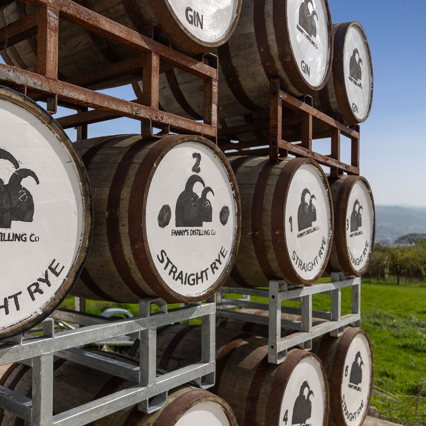 Casks of straight rye and gin maturing outside Fanny's Distillery, with views over the valley